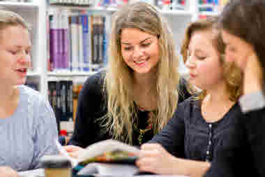 Fyra studenter på bibliotek