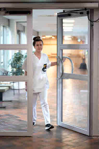 Lina Nilsson, sjuksköterska, gående genom en dörr, Centralsjukhuset Kristianstad. Årsberättelse 2021.