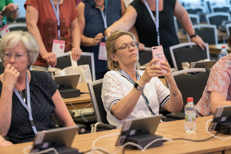 Paus under kongressen 2018. Ett kongressombud tar en bild med sin smartphone.
