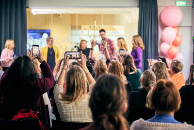 Jämställdhetsfrukost på Vårdförbundets hus 8 mars 2024. Publik bakifrån som fotograferar med mobiler