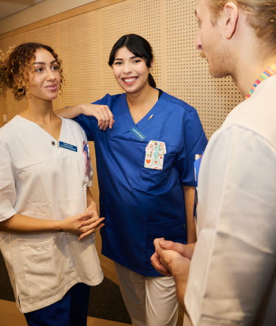 En manlig och en kvinnlig sjuksköterska samtalar med en röntgensjuksköterska