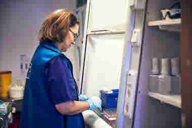 Sjuksköterska i profil som doserar medicin vid ett dragskåp, RIO äldreboende 