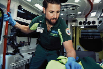Specialistsjuksköterska i ambulans vårdar patient.