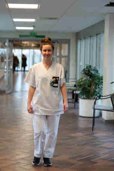 Lina Nilsson, sjuksköterska, gående 
i en korridor, Centralsjukhuset Kristianstad. Årsberättelse 2021.