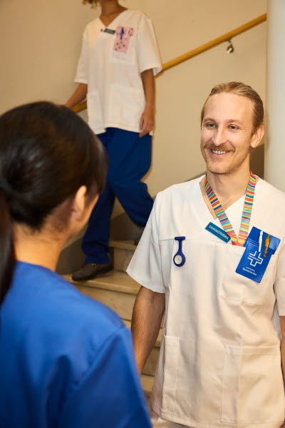 Man och kvinna. Sjuksköterskor möts i ett trapphus. 