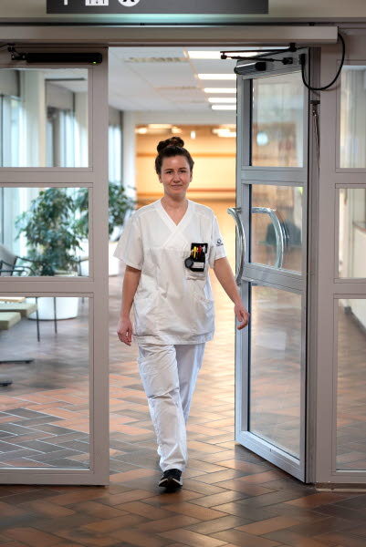 Lina Nilsson, sjuksköterska, gående genom en dörr, Centralsjukhuset Kristianstad. Årsberättelse 2021.