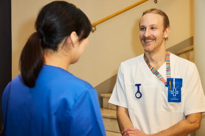 Man och kvinna. Sjuksköterskor möts i ett trapphus. 