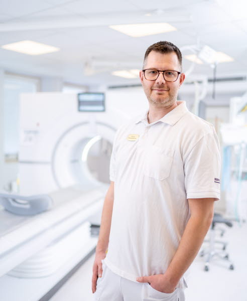 Henrik Nilsson Drott stående vid en röntgen, chefsmedlem, verksamhetsutvecklare i medicinsk diagnostik och teknik, Västmanland. Årsberättelse 2021.