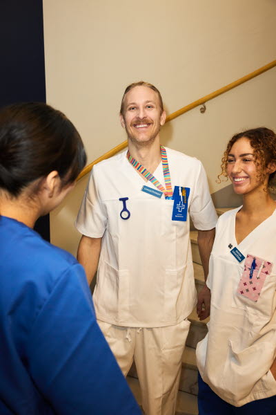 Man och kvinna. Sjuksköterskor och röntgensjuksköterska möts i ett trapphus. 