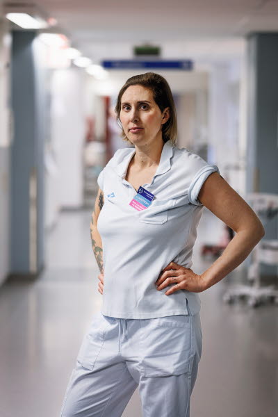 Marja-Lise Berkelder, sjuksköterska, förtroendevald, allvarlig, bestämd, stående i en korridor, Norrlands Universitetssjukhus, Umeå. Årsberättelse 2021.