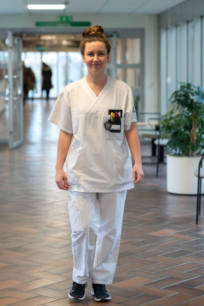Lina Nilsson, sjuksköterska, gående i en korridor, beskuren, Centralsjukhuset Kristianstad. Årsberättelse 2021.