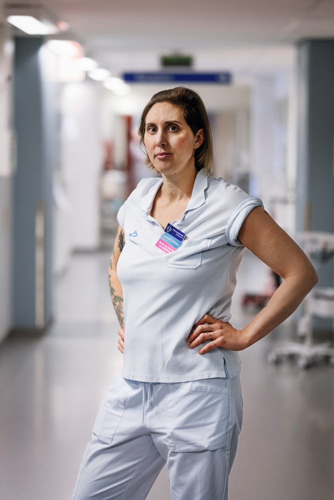 Marja-Lise Berkelder, sjuksköterska, förtroendevald, allvarlig, bestämd, stående i en korridor, Norrlands Universitetssjukhus, Umeå. Årsberättelse 2021.