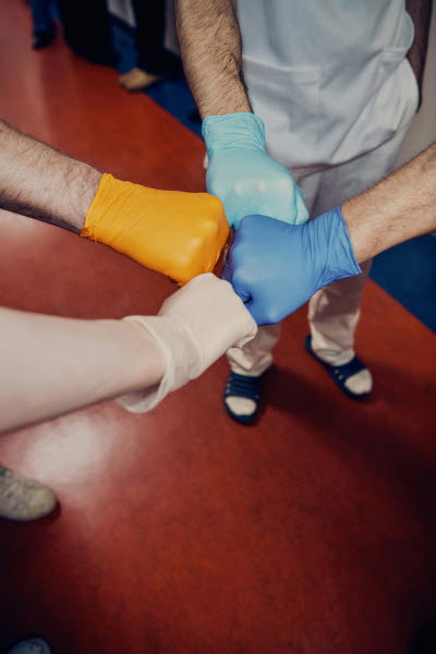 Fyra olikfärgade handskar. knutna nävar som möter varandra. Gemenskap, olikhet