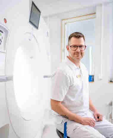 Henrik Nilsson Drott sittande vid en röntgen, chefsmedlem, verksamhetsutvecklare i medicinsk diagnostik och teknik, Västmanland. Årsberättelse 2021.