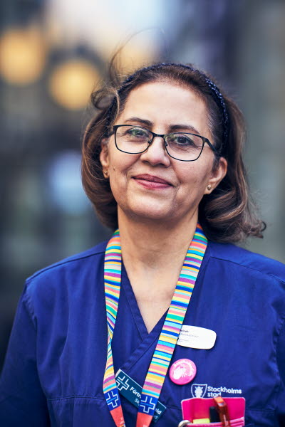 Sjuksköterska doserar medicin RIO äldreboende. Porträtt utomhus, stående.